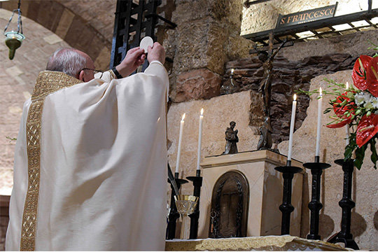 Pope Francis celebrates the Eucharist at the tomb of St. Francis in the crypt of the Basilica of St. Francis in Assisi, Italy, Oct. 3, 2020. The pope signed his new encyclical, "Fratelli Tutti, on Fraternity and Social Friendship," at the end of the Mass.